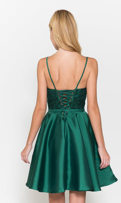 A woman models the Short A-Line Homecoming Dress with Pockets 8694, featuring a sleeveless green satin design and lace-up corset back, standing against a white background.