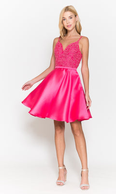 A woman wears the Short A-Line Homecoming Dress with Pockets 8694—sleeveless, bright pink with a lace bodice and flared satin skirt—paired with strappy heels against a plain white background.