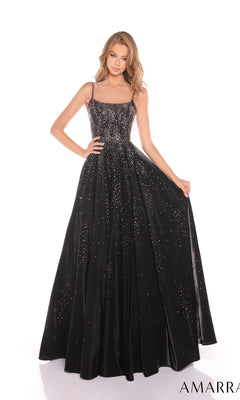 A woman wearing the Amarra 87292 Long Prom Dress?a floor-length black gown with thin straps, sparkling embellishments, and a sleek satin a-line skirt?stands against a white background.