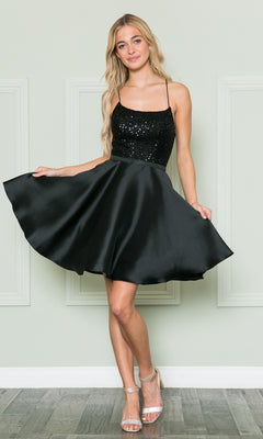 A woman stands before a light wall in the Sequin-Bodice Short Flared Homecoming Dress 8730, featuring a black sequined bodice, satin skirt, and paired with silver high-heeled sandals.