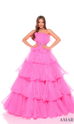 A woman smiles with her hands on her hips, wearing the Long Formal Dress 88083 by Amarra?a bright pink, strapless gown with a beaded waist?against a white background.