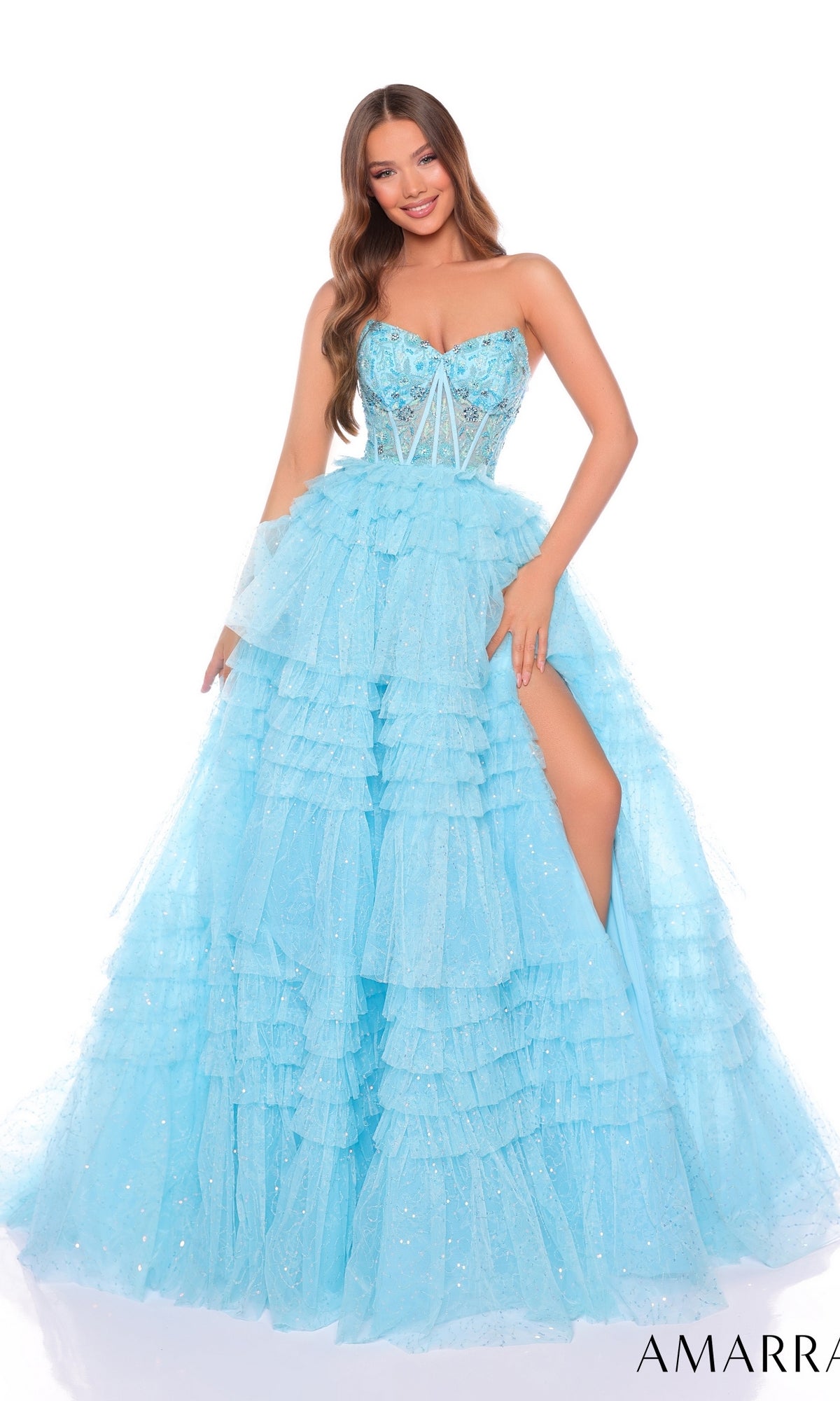 A woman wearing the Long Formal Dress 88099 by Amarra—a light blue strapless ball gown with ruffle layered tiers, sparkly embellishments, a high slit, and a fitted bodice.