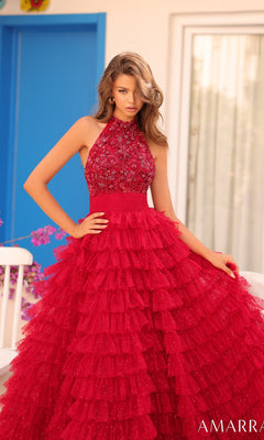 A woman stands outdoors near a white chair wearing the Long Formal Dress 88102 by Amarra, featuring a sleeveless halter neck, beaded bodice, and layered tulle skirt.