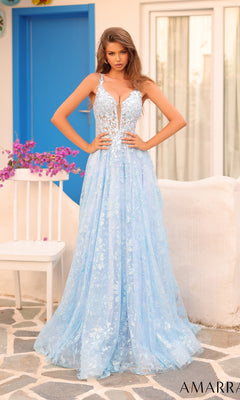 A woman stands outdoors near a white chair with pink flowers, wearing the Long Formal Dress 88126 by Amarra—a light blue, lace-embellished sleeveless gown with a corset bodice—in front of a blue door.