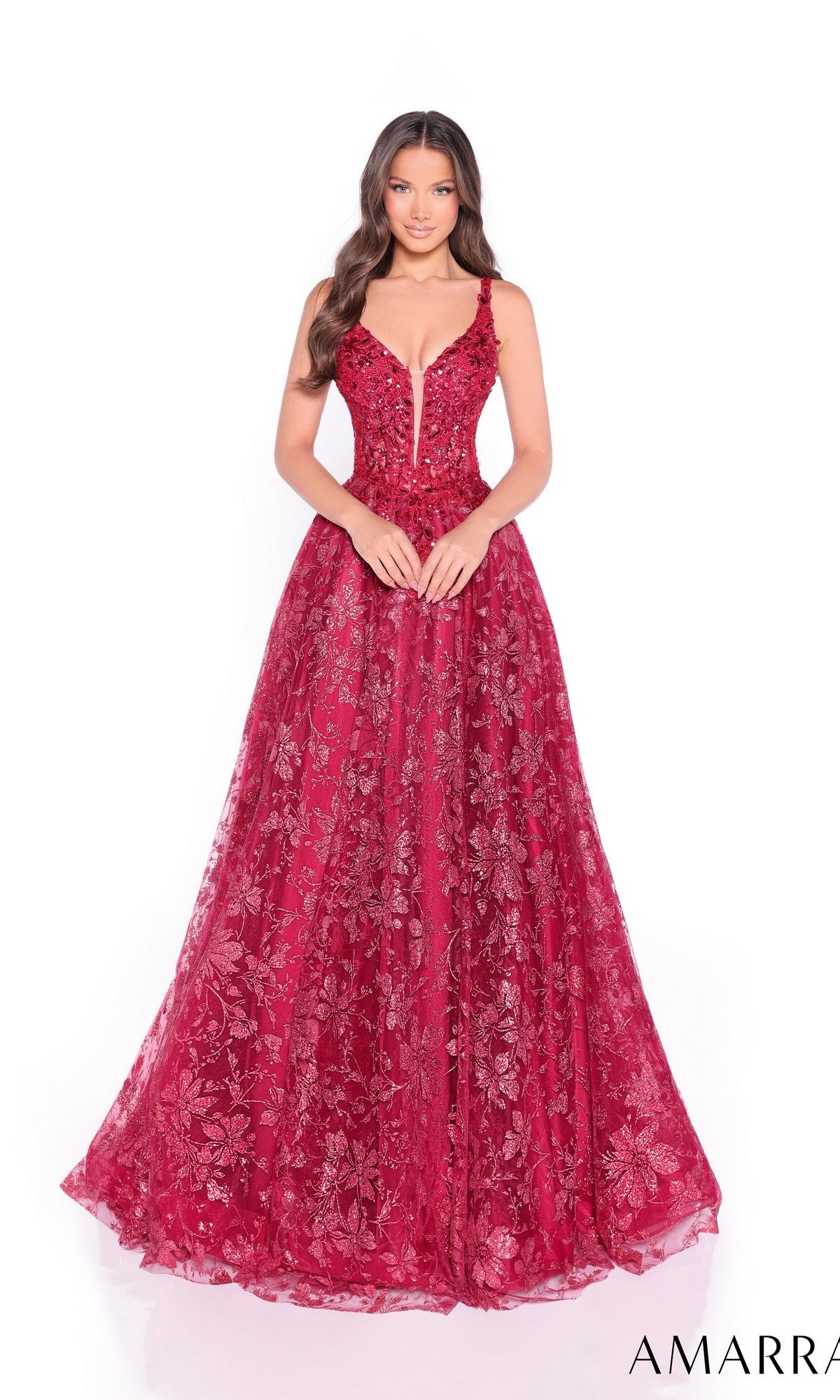 A woman faces forward in the Long Formal Dress 88126 by Amarra—a sleeveless, deep red A-line ball gown with a plunging neckline, floral patterns, and a delicate corset bodice.