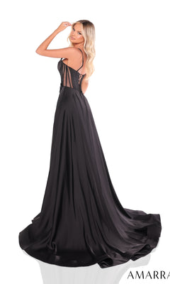 Woman wears the Amarra 88214 long prom dress with a black satin corset bodice, sheer back, and high leg slit, standing on a white background and glancing over her shoulder.