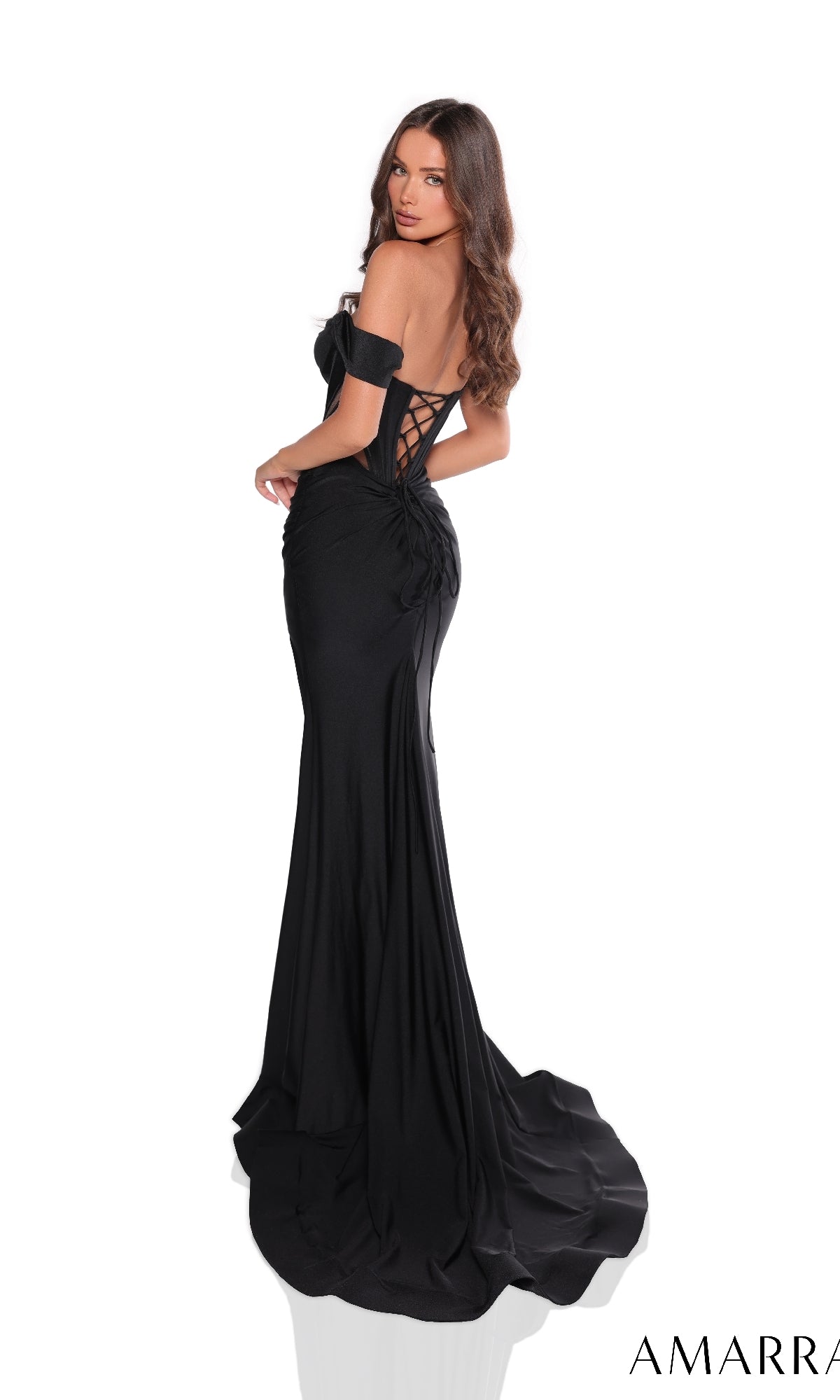 A woman in the Amarra 88220 long prom dress?fitted, off-the-shoulder with a boned-corset bodice, lace-up back, and thigh-high slit?stands looking over her shoulder against a white background.