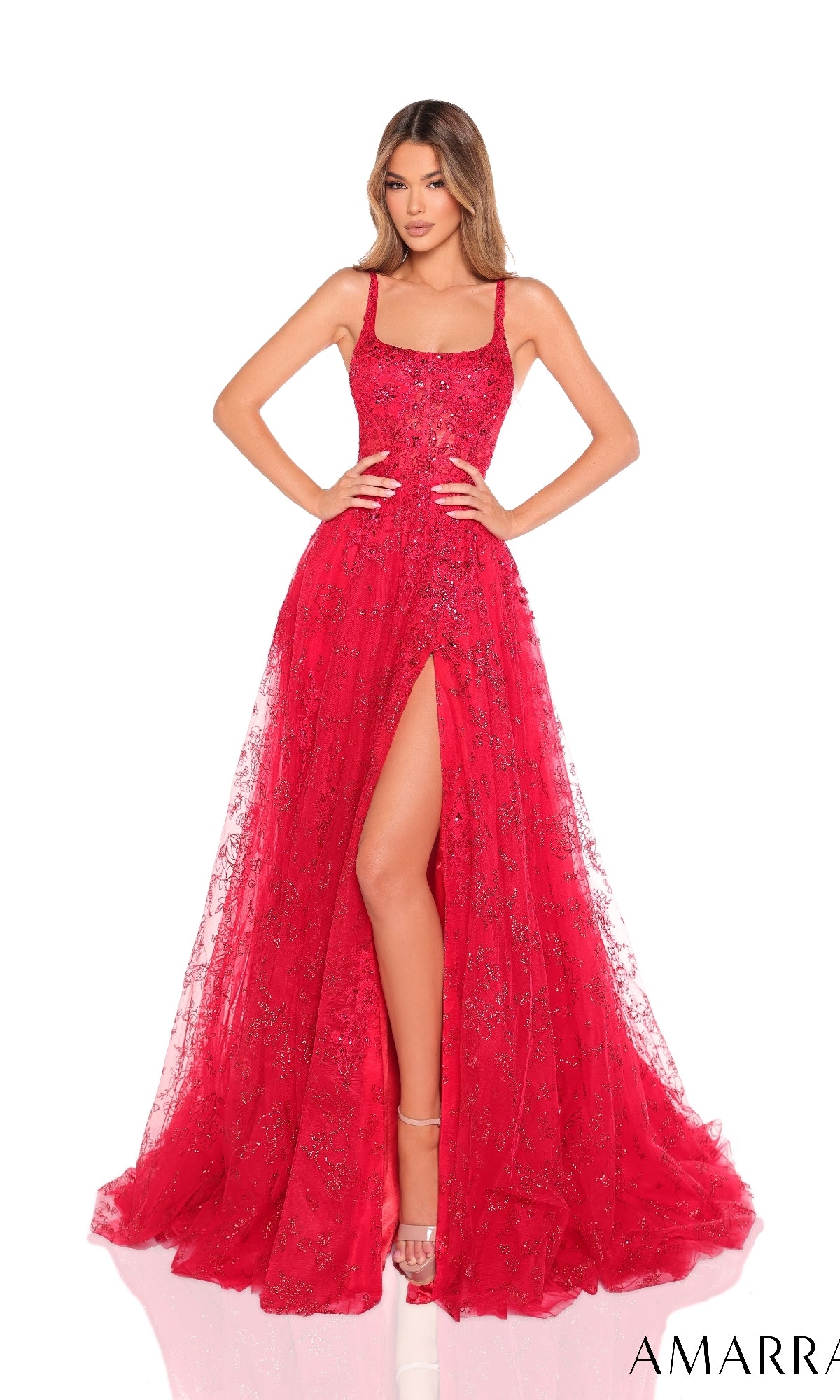A woman stands against a white background wearing the Amarra 88240, a sleeveless, floor-length sequin A-line prom dress featuring a high slit and sparkling embellishments.