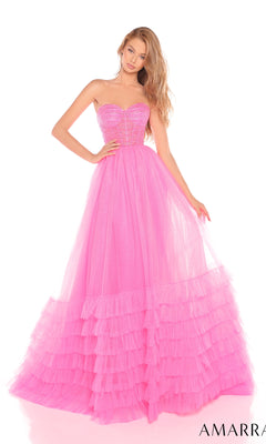A woman poses against a white background in the Amarra 88277 Strapless Prom Ball Gown, featuring a sweetheart neckline and bright pink tulle a-line ruffled skirt.