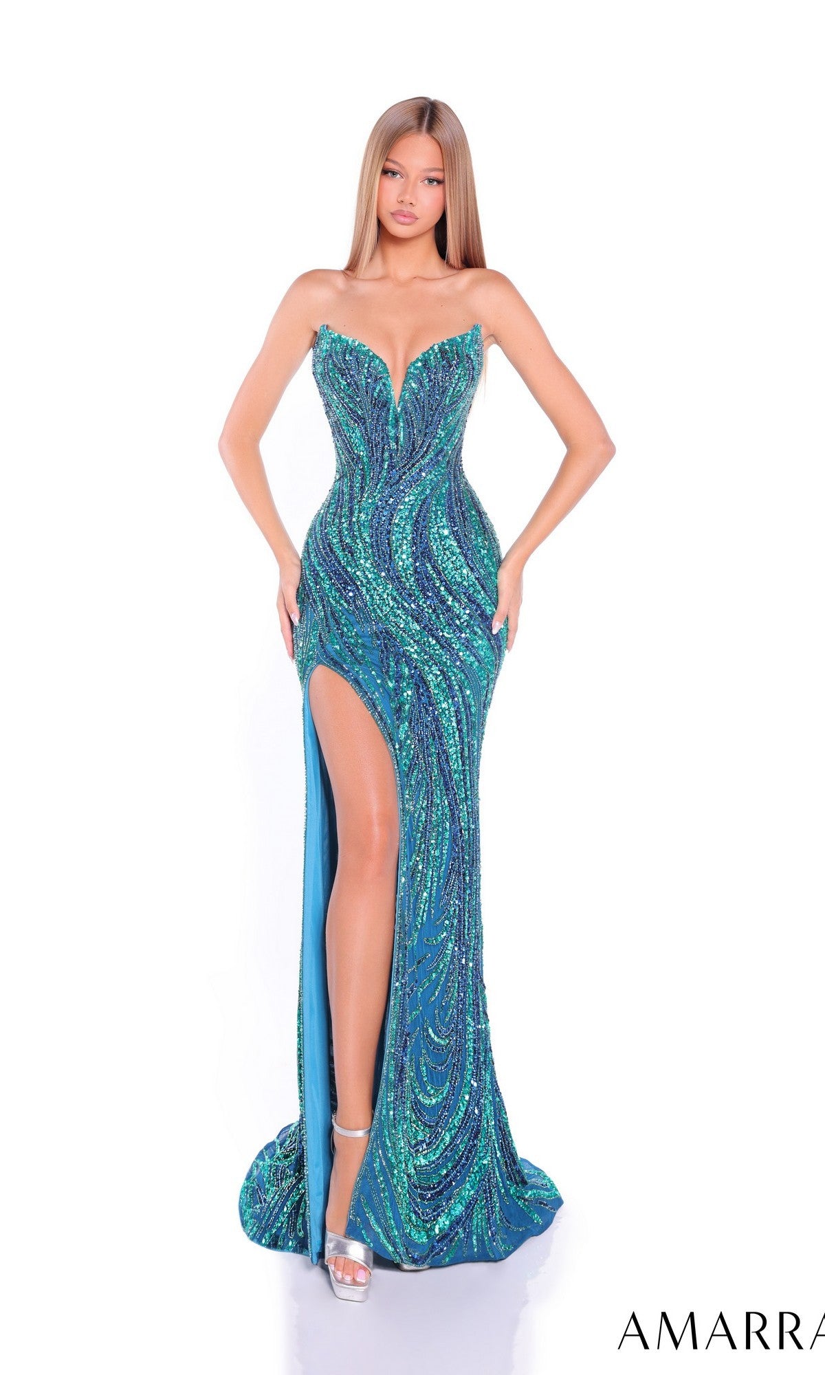 A woman in the Amarra 88291-1 long prom dress, featuring a strapless fitted design with green and blue sequins and a thigh-high slit, stands against a white background.
