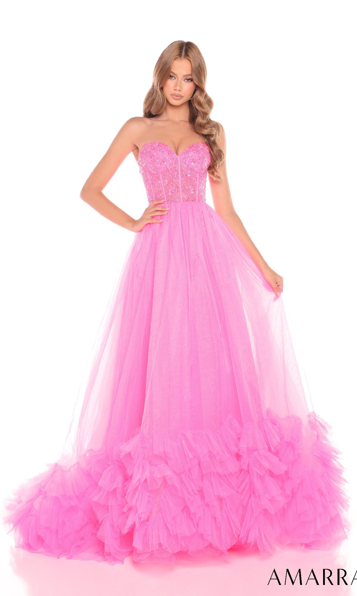 A woman wears the Amarra 88339 long prom dress, featuring a strapless, sequin-embellished corset bodice and a floor-length tulle skirt with ruffled layers at the hem, standing against a white background.
