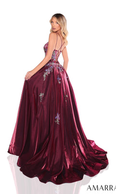 A woman poses against a white background wearing the Amarra 88379 long prom dress in burgundy, featuring elegant floral embroidery and a strappy open back.