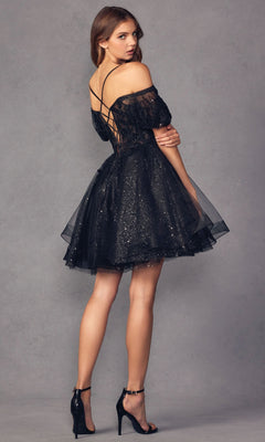 A woman poses against a plain gray background in the Puff-Sleeve Short A-Line Shimmer Prom Dress 886—an affordable, black, off-the-shoulder dress with glitter accents and lace-up back—paired with black high-heeled sandals.