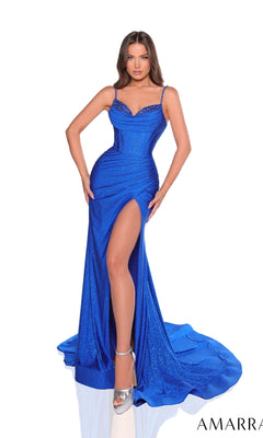 A woman models the Amarra 88760 long glitter-jersey prom dress in royal blue, featuring spaghetti straps, a fitted bodice, high slit, and floor-length train. She pairs it with silver high heels for a stunning formal look.