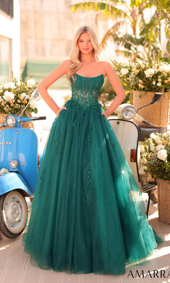 A woman stands outdoors in the Strapless Long Prom Ball Gown, Amarra 88913, a green dress with a sheer lace corset, near a blue scooter and flower arrangements.