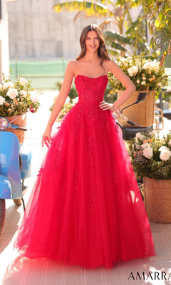 A woman stands outdoors in the Strapless Embroidered Prom Ball Gown: Amarra 88950, featuring a sweetheart neckline, floral embroidery, and a fitted bodice. White flowers and a blue scooter add charm to the background.