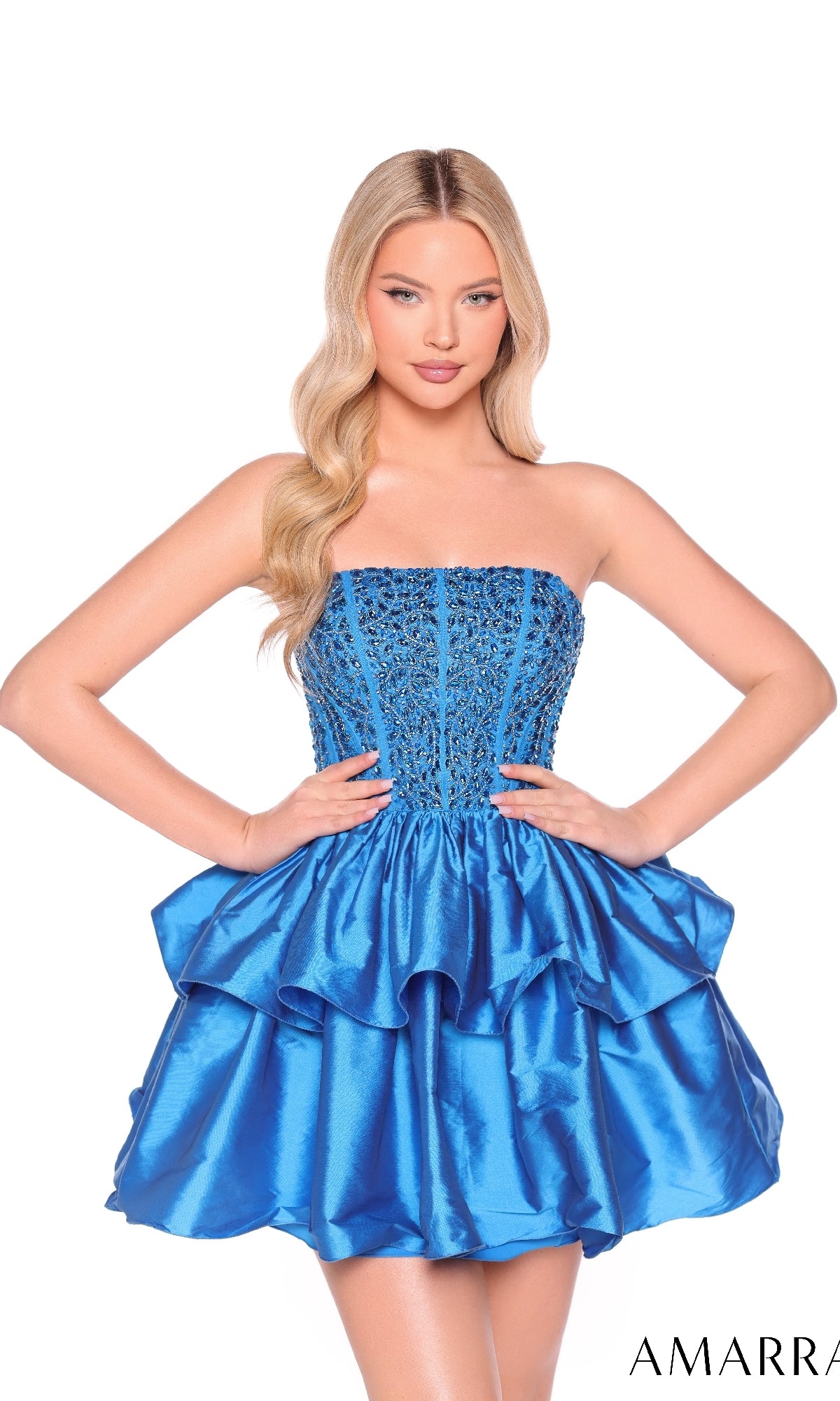 A woman poses in the Amarra 88952 Strapless Short Tiered Hoco Dress, featuring a beaded corset-style bodice and ruffled mini skirt, against a white background.