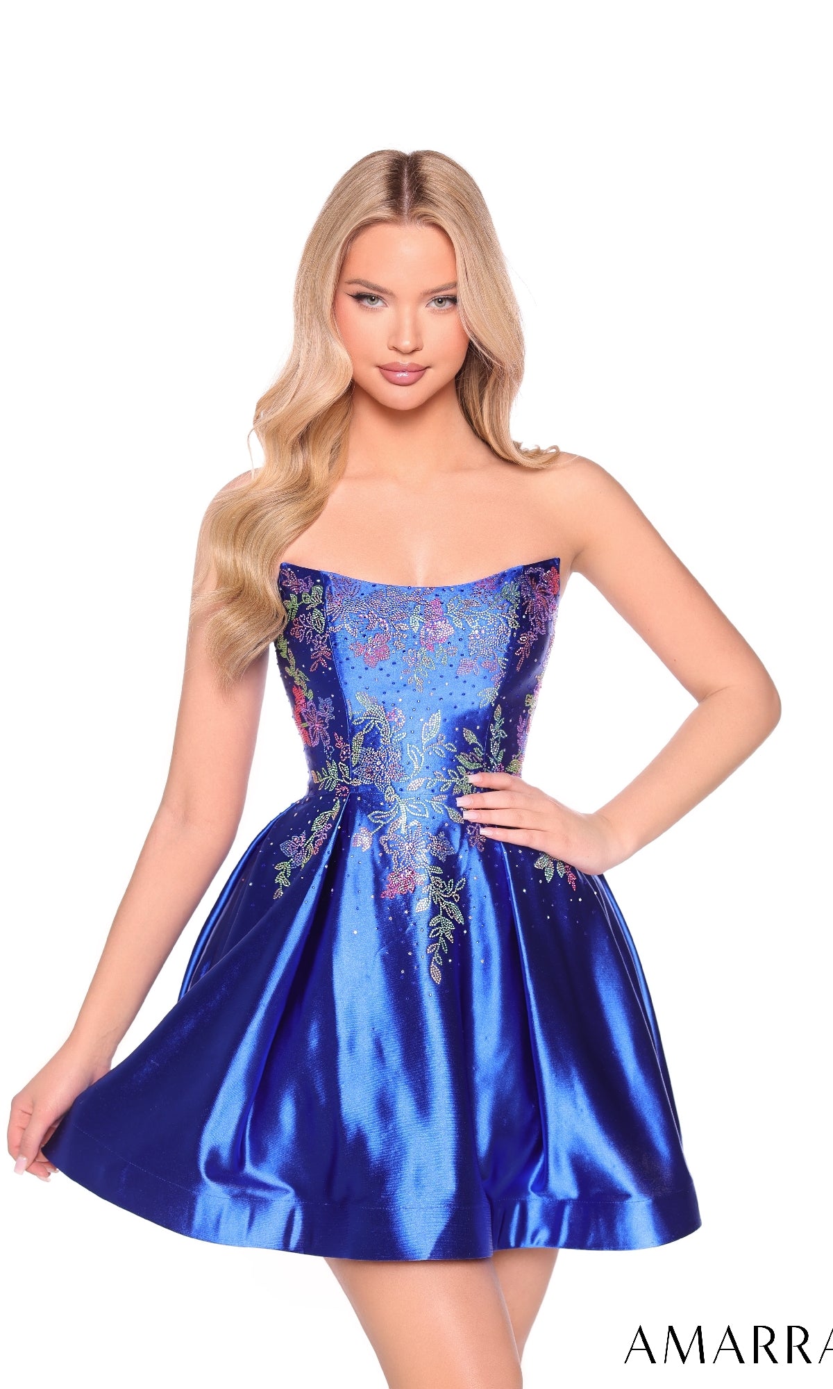 A woman models the Strapless Fit-and-Flare Hoco Dress: Amarra 88962—a shiny blue, floral-embroidered, short A-line party dress—standing against a plain white background.