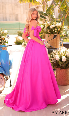 A woman in a bright pink Amarra 88995 Lace-Up Off-Shoulder Prom Ball Gown stands outdoors near white flower arrangements and a blue scooter.