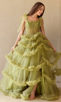 Woman wearing a green, tiered ball gown with ruffles against a neutral background