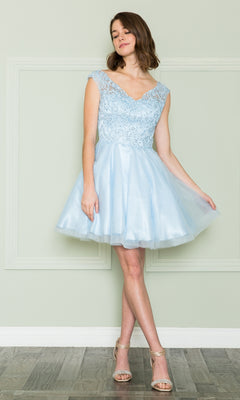 A woman wears the Lace-Bodice Short Babydoll Homecoming Dress 8902, a light blue dress with lace and sequin details, standing against a pale green wall while holding the skirt and wearing strappy heels.