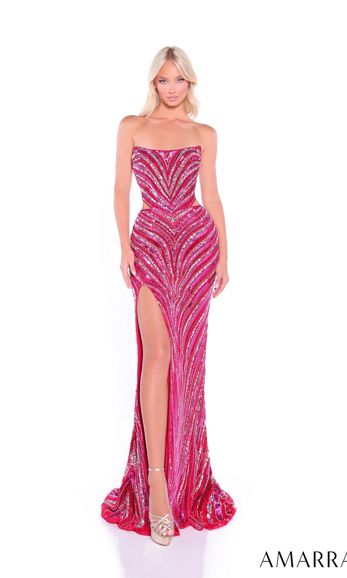 A woman in the Amarra 89109 long prom dress—strapless, red and pink with sequin embellishments and a high-leg side slit—stands in silver heels against a white background.