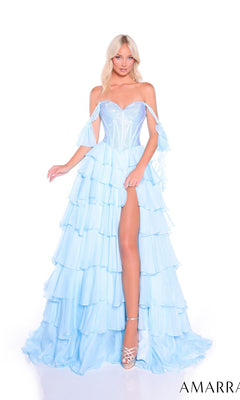 A woman in the Amarra 89285 long prom dress, featuring a light blue off-the-shoulder design, tiered chiffon skirt, and thigh-high slit, pairs it with silver high heels while standing against a white background.