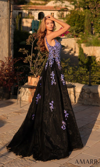 A woman poses outdoors in the Amarra 89373 long prom dress, featuring a sleeveless design, purple floral accents, and a fitted silhouette, as she stands on a stone patio surrounded by lush greenery.