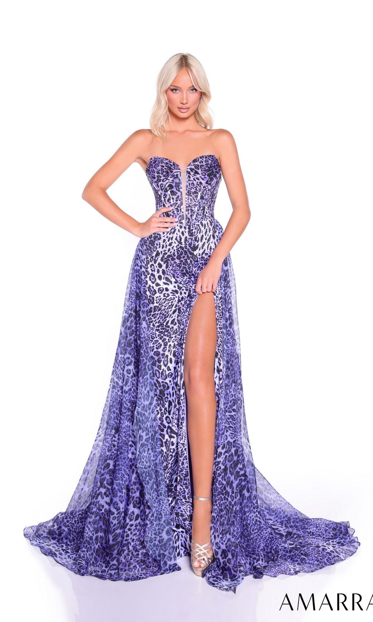 A woman models the Amarra 89397 Strapless Leopard-Print Prom Gown—a purple dress with a thigh-high slit and silver heels—standing against a white background.