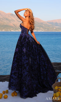 A woman poses by the sea and mountains with a basket of lemons, wearing the Amarra 89415 long prom dress featuring a strapless bodice and an A-line tulle skirt.
