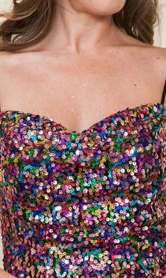 A woman wears the Multicolored Short Sequin Homecoming Dress 8944, a strapless sweetheart party dress with vibrant sequins and visible black bra straps.
