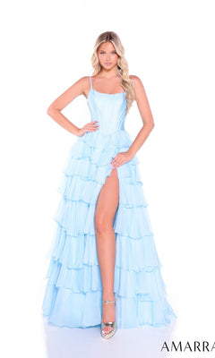A woman poses in the Amarra 89461 Ruffled Long Tiered Prom Dress in light blue, featuring a high slit and ruffles, paired with silver heels against a white background.