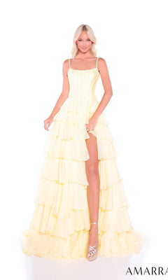 A woman in the Amarra 89461 Ruffled Long Tiered Prom Dress, a light yellow a-line gown with thin straps, tiered ruffles, and high slit, stands against a white background wearing silver platform heels.
