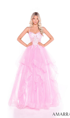 A woman poses against a white background wearing the Amarra 89504: a light pink, lace-up, long tiered prom dress with spaghetti straps and a fitted, embellished bodice.