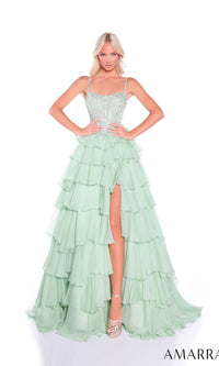 A woman poses with hands on hips in the Amarra 89507 long prom dress, featuring a light green embellished corset bodice and a tiered ruffle chiffon skirt, set against a white background.