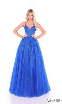 A woman wears the Amarra 89509 long prom dress—a vibrant blue gown with spaghetti straps, floral embellishments, a lace corset bodice, and a flowing tulle A-line skirt—standing against a white background.
