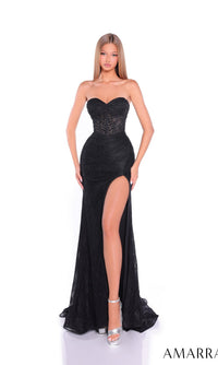 A woman poses against a white background in the Amarra 89521 long prom dress, a strapless black gown with a sheer corset bodice and high-leg slit. She completes the elegant, floor-length look with silver heels.