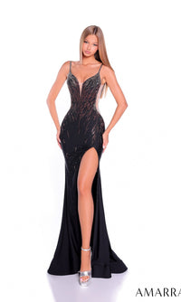 A woman poses in the black Amarra 89529 long prom dress, featuring a beaded bodice, high-leg slit, sheer side panels, and silver embellishments. She completes the look with silver platform heels against a white background.