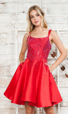 A woman in the Beaded Short A-Line Homecoming Dress 8958, featuring a sparkly fitted bodice and flared skirt, stands before a rustic white wooden backdrop.
