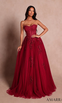 A woman wearing the Amarra 89626 long prom dress in wine, featuring a strapless, floor-length ball-gown silhouette with lace detailing and a sweetheart neckline, stands against a plain beige background.