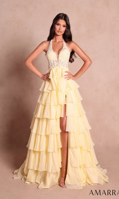 A woman stands against a plain beige background wearing the Amarra 89633 long prom dress in light yellow, which features a halter neckline, beaded bodice, and a tiered ruffle skirt.