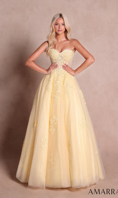 A woman wearing the Amarra 89688 long prom dress in light yellow, featuring a strapless design, floral embroidery, and a classic floor-length ball-gown skirt, stands against a neutral background.