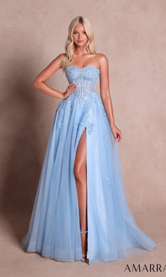 A woman poses in the Amarra 89689 long prom dress—a light blue gown featuring floral embroidery, a sheer bodice, and a thigh-high slit—standing against a beige background.