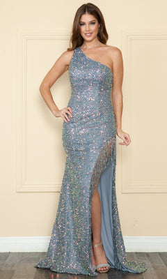 A woman stands against a beige wall wearing the Fringe One-Shoulder Long Sequin Prom Dress 8984, featuring a shimmering design with a high slit and fringe details.