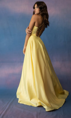 A person wearing a yellow Eureka 9008 Strappy-Back Long Satin Prom Dress featuring a long, satin formal design with a strappy open-back and lace-up detail.