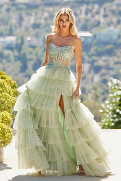 Amelia Couture 9053 sage green strapless evening gown featuring a beaded, semi-sheer corset bodice and a tiered tulle skirt with a high leg slit.