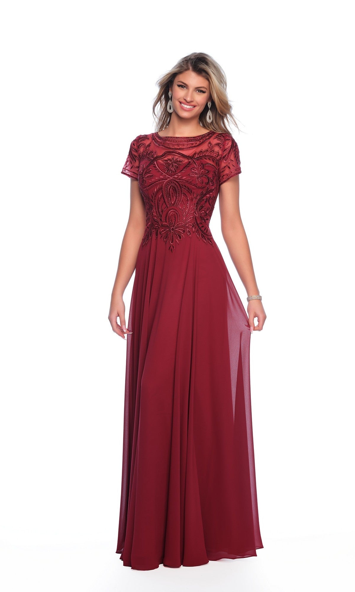 A woman in a floor-length burgundy Dave & Johnny A9071 dress with short sleeves, intricate beaded bodice, and flowing chiffon skirt stands against a white background—an elegant formal A-line gown.