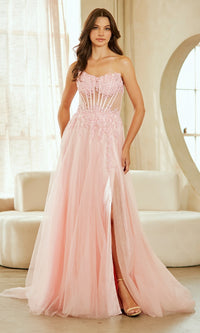 Woman wearing a pink evening gown with a high slit in a softly lit room.