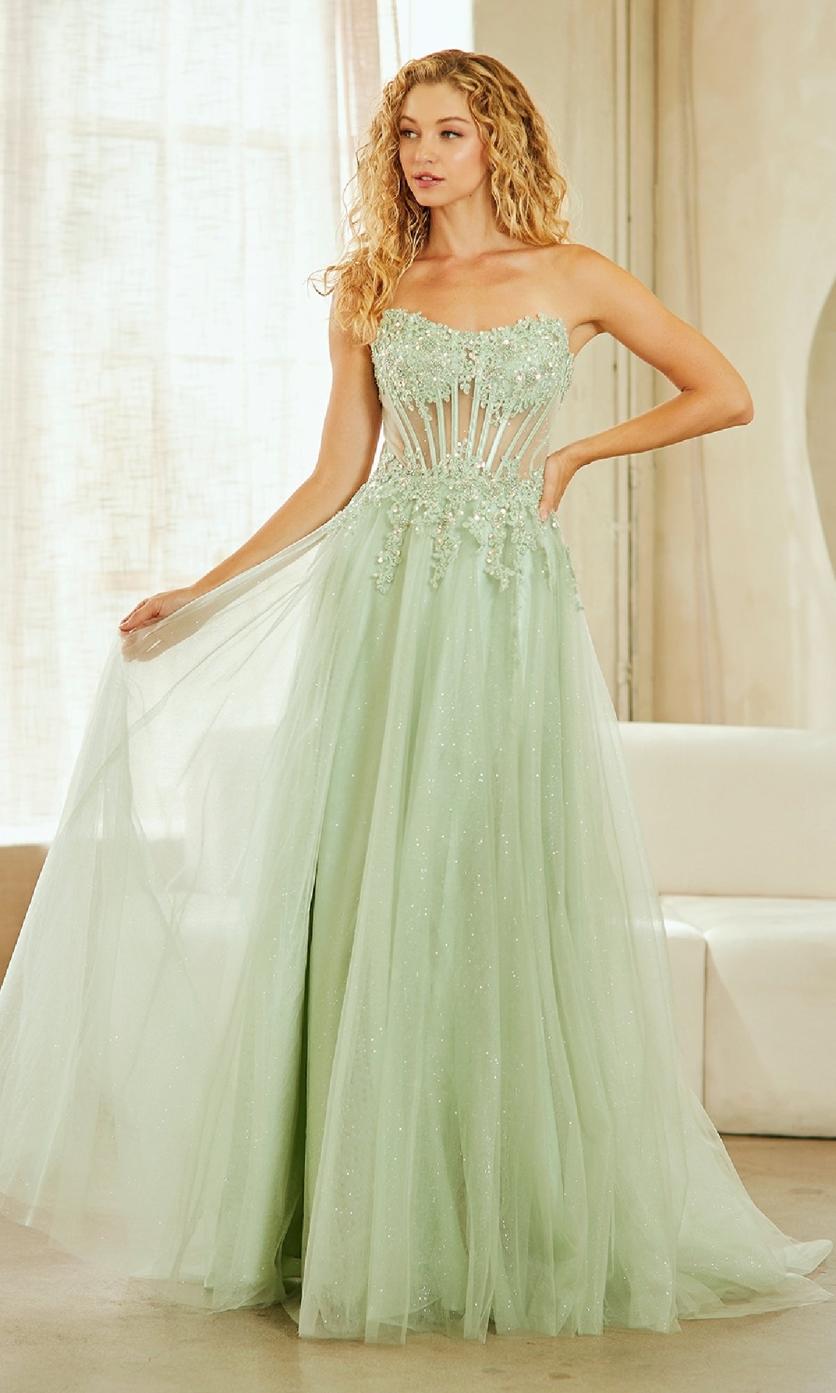 Woman wearing a light green strapless gown with intricate detailing indoors.