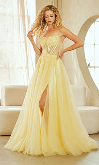 Woman wearing a yellow evening gown with a slit in a well-lit room.